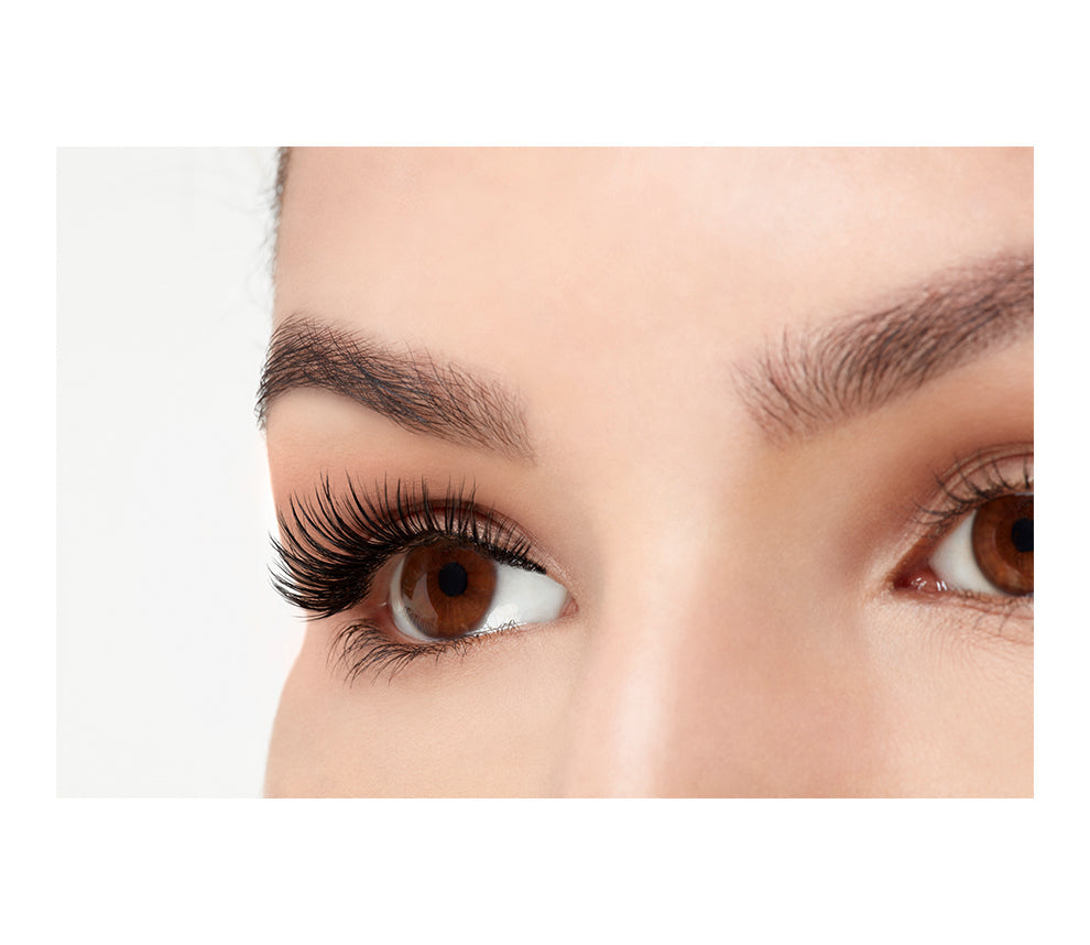A model wearing Ardell 3D Faux Mink Wispies in a side view emphasizing the curly, flared & natural lash look