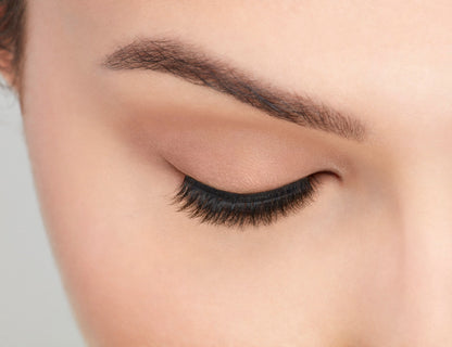 An extreme front shot of closed eye wearing a Fauxmink 815 by Ardell creating a natural, elongated & curly lash
